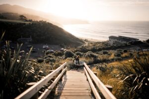 Surfer with board running down to the beach in Raglan Waikato New Zealand Merten Snijders sxxXcV